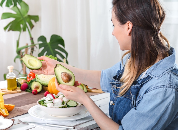 Foto gratuito giovane e donna felice guardando l'avocado a tavola
