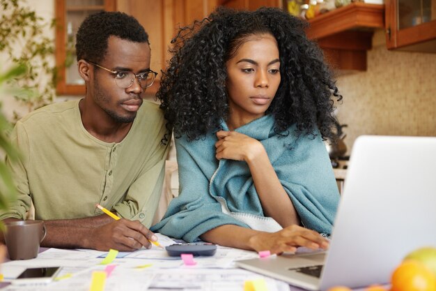 Giovane famiglia afro-americana che fa insieme lavoro di ufficio