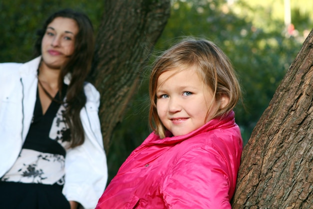 Giovane famiglia che fa passeggiata sana attraverso il parco di autunno