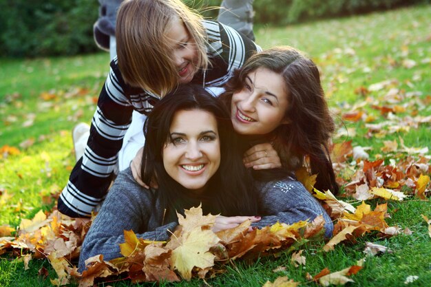 Giovane famiglia che fa passeggiata sana attraverso il parco di autunno