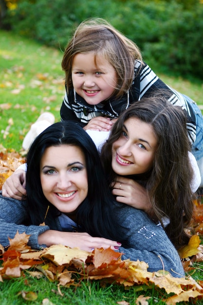 Giovane famiglia che fa passeggiata sana attraverso il parco di autunno