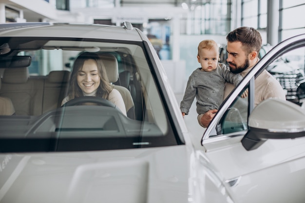 Giovane famiglia con bambina che sceglie un'auto