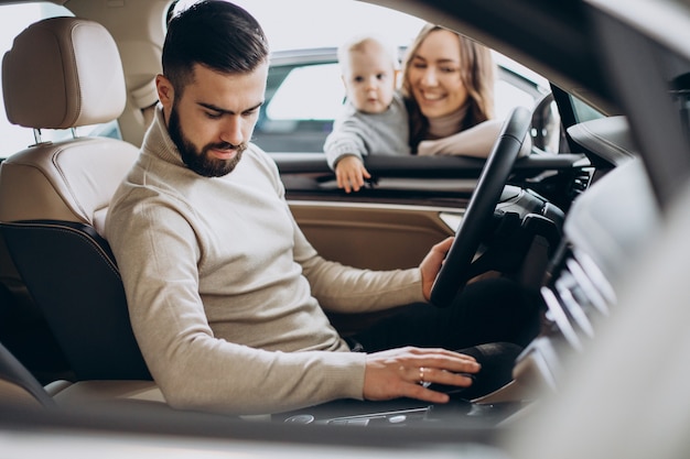 Giovane famiglia con bambina che sceglie un'auto