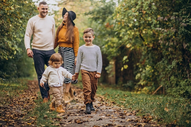 Giovane famiglia con bambini nella sosta di autunno