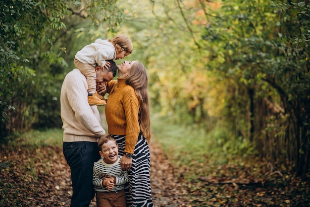 Giovane famiglia con bambini nella sosta di autunno