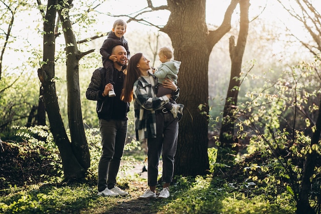 Giovane famiglia con i loro bambini che si divertono nella foresta