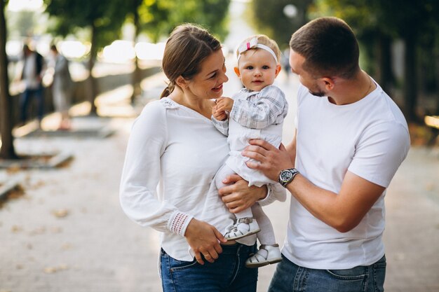 Giovane famiglia con la loro piccola figlia in autunno parco