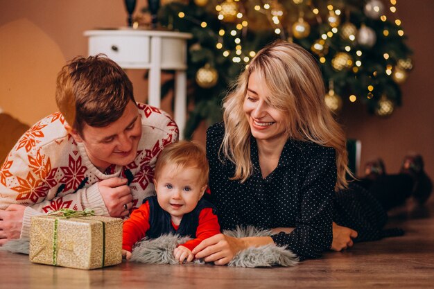 Giovane famiglia con la piccola figlia che tiene i regali di Natale