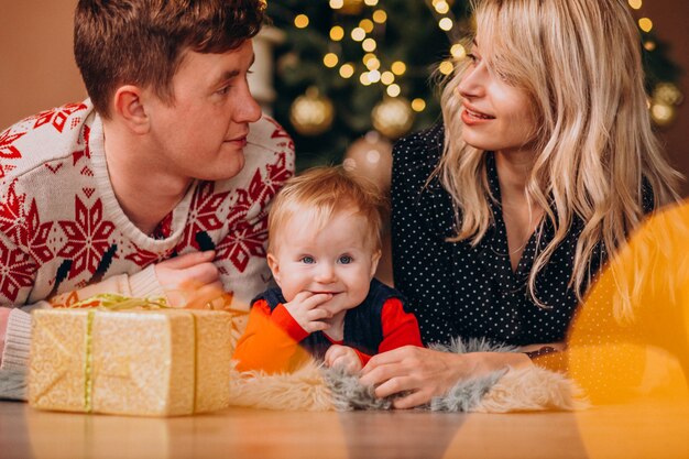 Giovane famiglia con la piccola figlia che tiene i regali di Natale