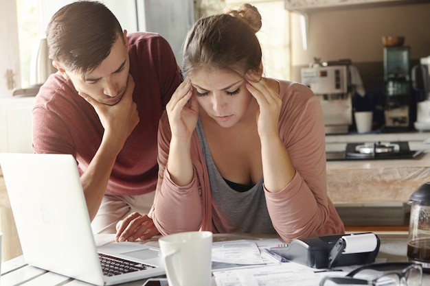 Giovane famiglia con molti debiti che affrontano lo stress finanziario