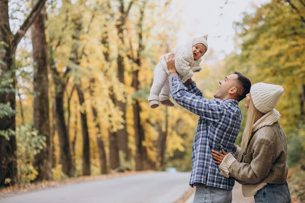 Giovane famiglia con piccola figlia nel parco autunnale