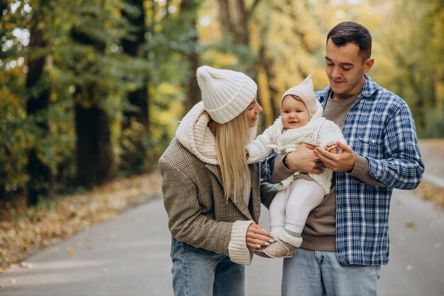 Giovane famiglia con piccola figlia nel parco autunnale