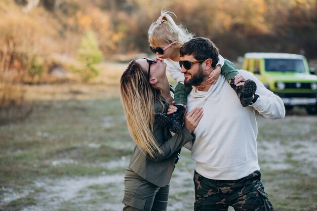 Giovane famiglia moderna che viaggia in auto e si ferma per una passeggiata nel parco