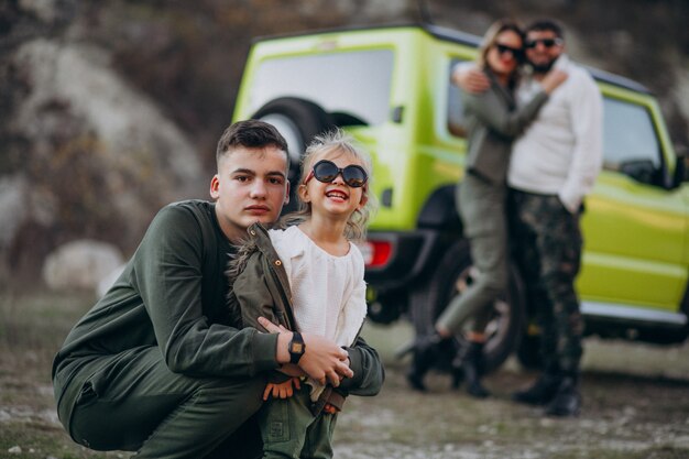 Giovane famiglia moderna che viaggia in auto e si ferma per una passeggiata nel parco