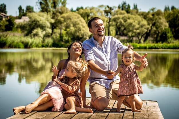 giovane famiglia sul molo vicino al lago