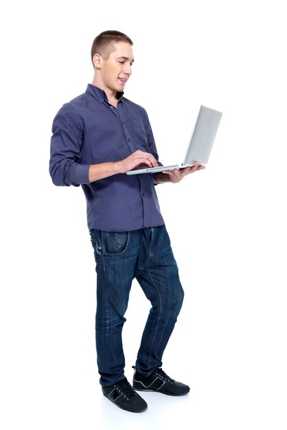 Giovane felice con il potrait di profilo del computer portatile - isolato su bianco