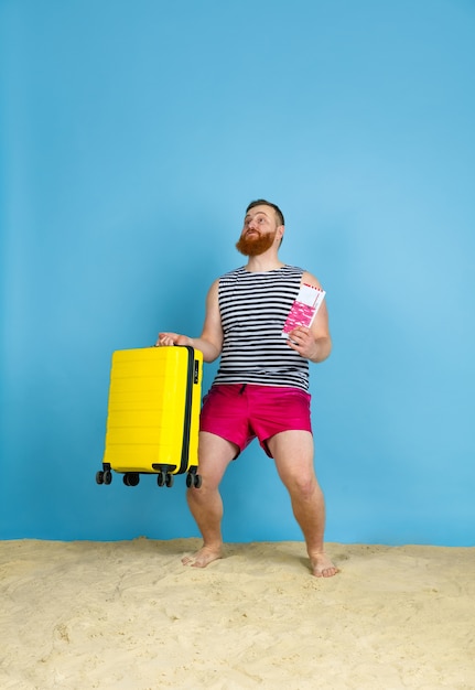 Giovane felice con la borsa preparata per viaggiare nello spazio blu