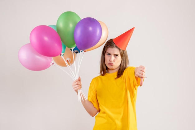 giovane femmina che tiene palloncini colorati su bianco