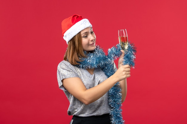 Giovane femmina di vista frontale che celebra il nuovo anno sul colore rosso di festa della festa di Natale della parete