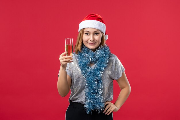 Giovane femmina di vista frontale che celebra il nuovo anno sul natale rosso di colore della parete