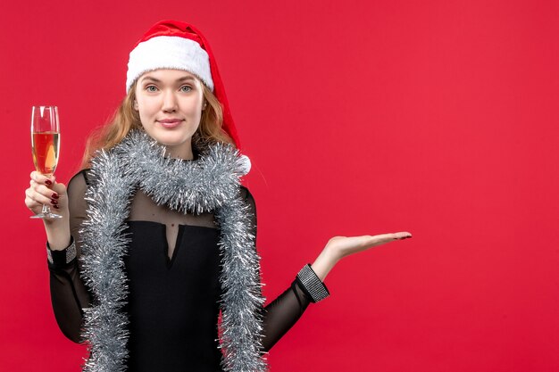 Giovane femmina di vista frontale che celebra il nuovo anno sul natale rosso di emozione di feste della parete