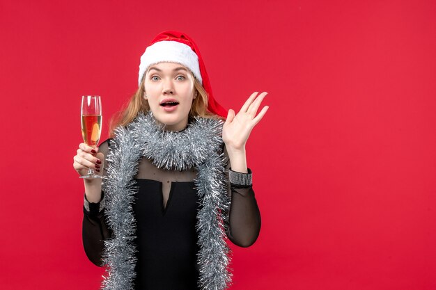 Giovane femmina di vista frontale che celebra il nuovo anno sull'emozione rossa di natale di festa della parete