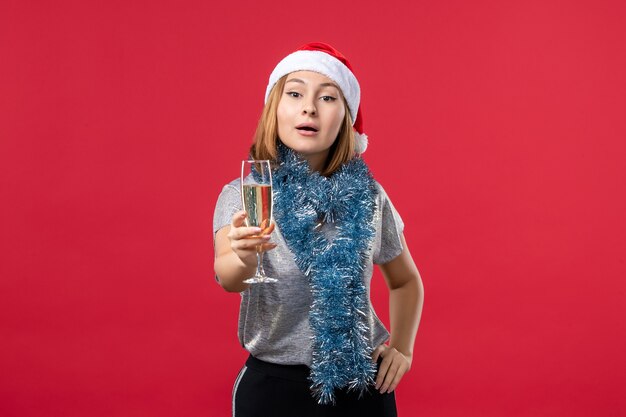 Giovane femmina di vista frontale che celebra il nuovo anno sulle vacanze di Natale di colore della parete rossa