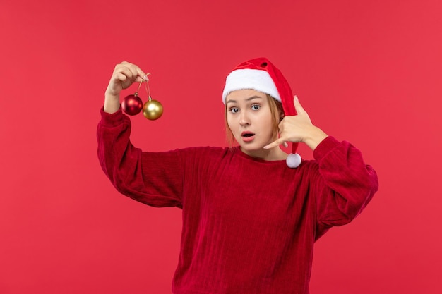 Giovane femmina di vista frontale che posa con i giocattoli di natale, emozione di natale di festa