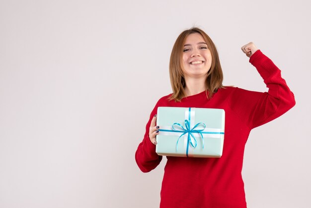 Giovane femmina di vista frontale che sta con il presente di natale