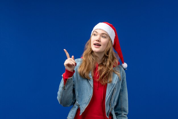 Giovane femmina di vista frontale con il cappuccio rosso di natale sulle vacanze di natale di emozione del fondo blu