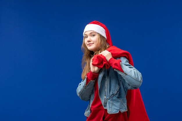 Giovane femmina di vista frontale con la borsa piena di regali sullo sfondo blu emozioni vacanza Natale