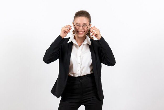 Giovane femmina di vista frontale in vestito classico rigoroso che posa e che sorride sulla donna del costume del lavoro del lavoro femminile di affari del fondo bianco