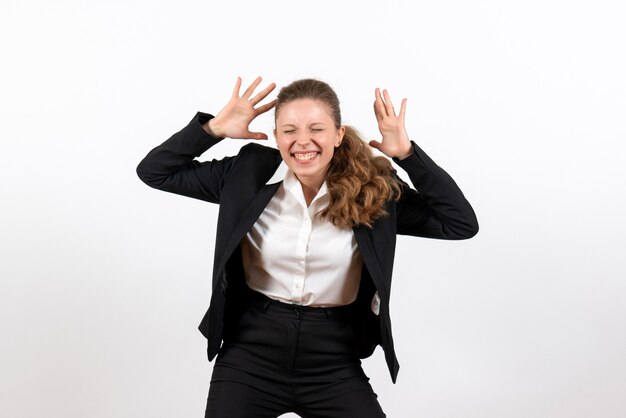 Giovane femmina di vista frontale in vestito classico rigoroso che posa sul lavoro del vestito di lavoro femminile della donna di affari del fondo bianco