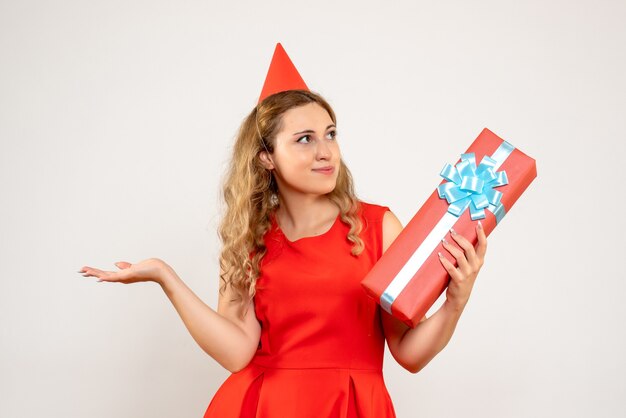 Giovane femmina di vista frontale in vestito rosso che celebra il natale con il presente