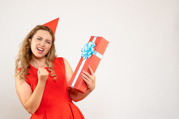 Giovane femmina di vista frontale in vestito rosso che celebra il natale con il presente