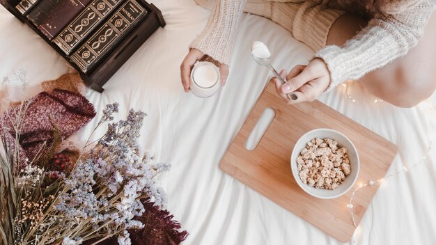 Giovane femmina godendo di yogurt sul letto