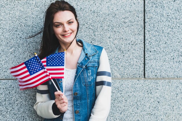 Giovane femmina in posa con bandiere americane