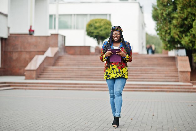 Giovane femmina nera poste in città Ritratto singolo di donne africane Tiene tablet a portata di mano
