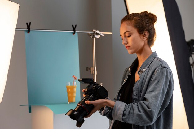 Giovane fotografo di prodotto femminile in studio