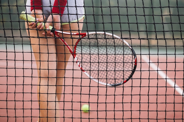 Giovane giocatore del primo piano di tennis sul campo