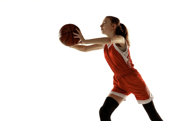 Giovane giocatore di basket femminile caucasico in azione, movimento in esecuzione isolato su sfondo bianco. Redhair ragazza sportiva. Concetto di sport, movimento, energia e stile di vita dinamico e sano. Formazione.