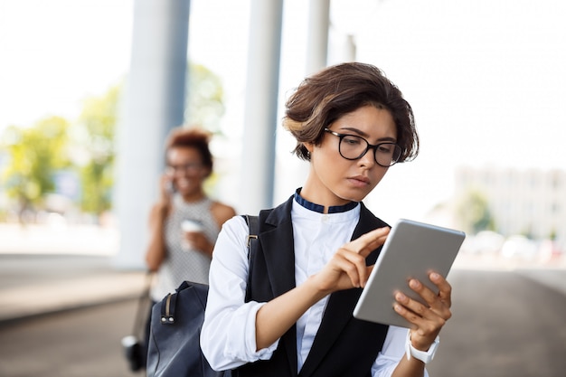 Giovane imprenditrice di successo guardando tablet su business center.