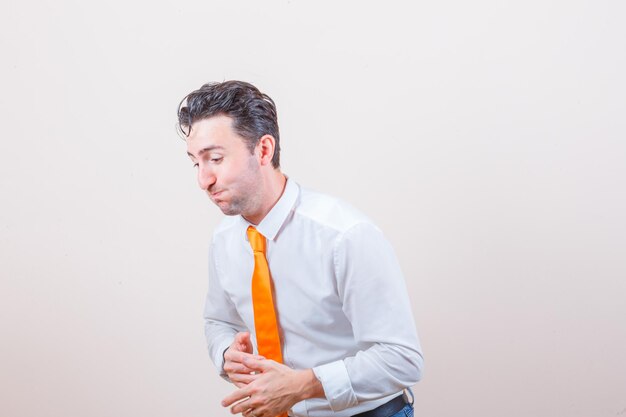 Giovane in camicia bianca, jeans che trova qualcosa di comico