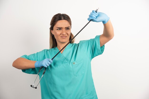 Giovane infermiera femminile che posa con lo stetoscopio.