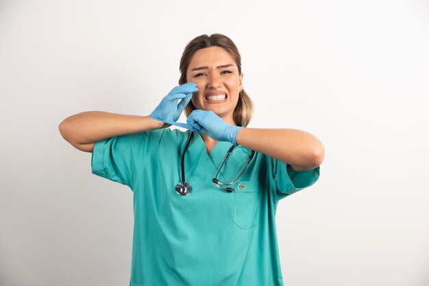 Giovane infermiera femminile in posa vestita in abito medico.