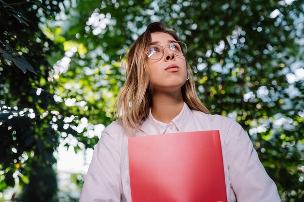 Giovane ingegnere agricolo femminile che lavora nella serra