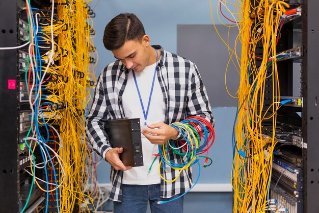 Giovane ingegnere di rete che esamina gli interruttori Ethernet