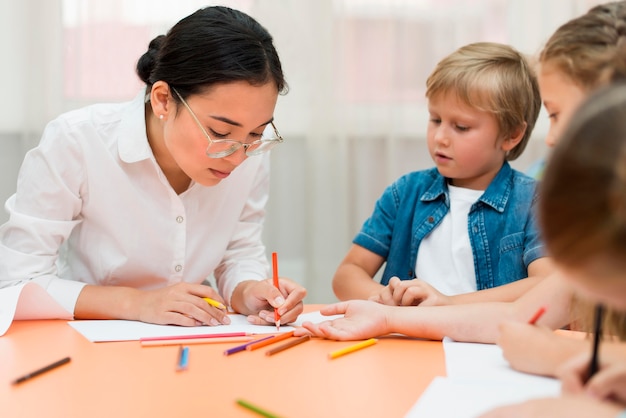 Giovane insegnante che fa la sua classe con i bambini