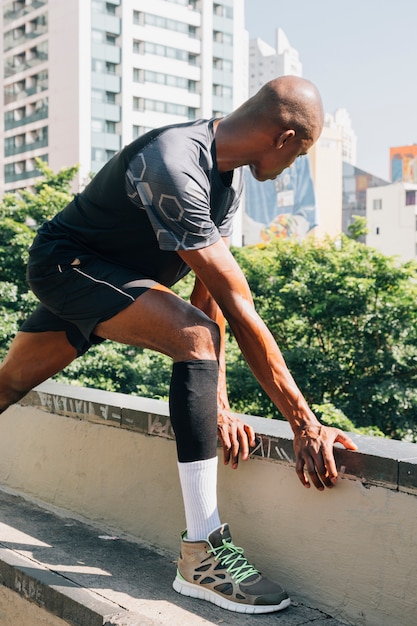 Giovane jogger maschio formazione e facendo allenamento all&#39;aperto in città