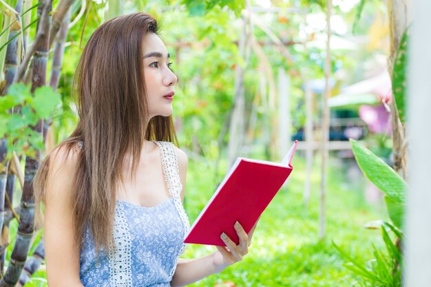 Giovane libro di lettura grazioso della donna in parco